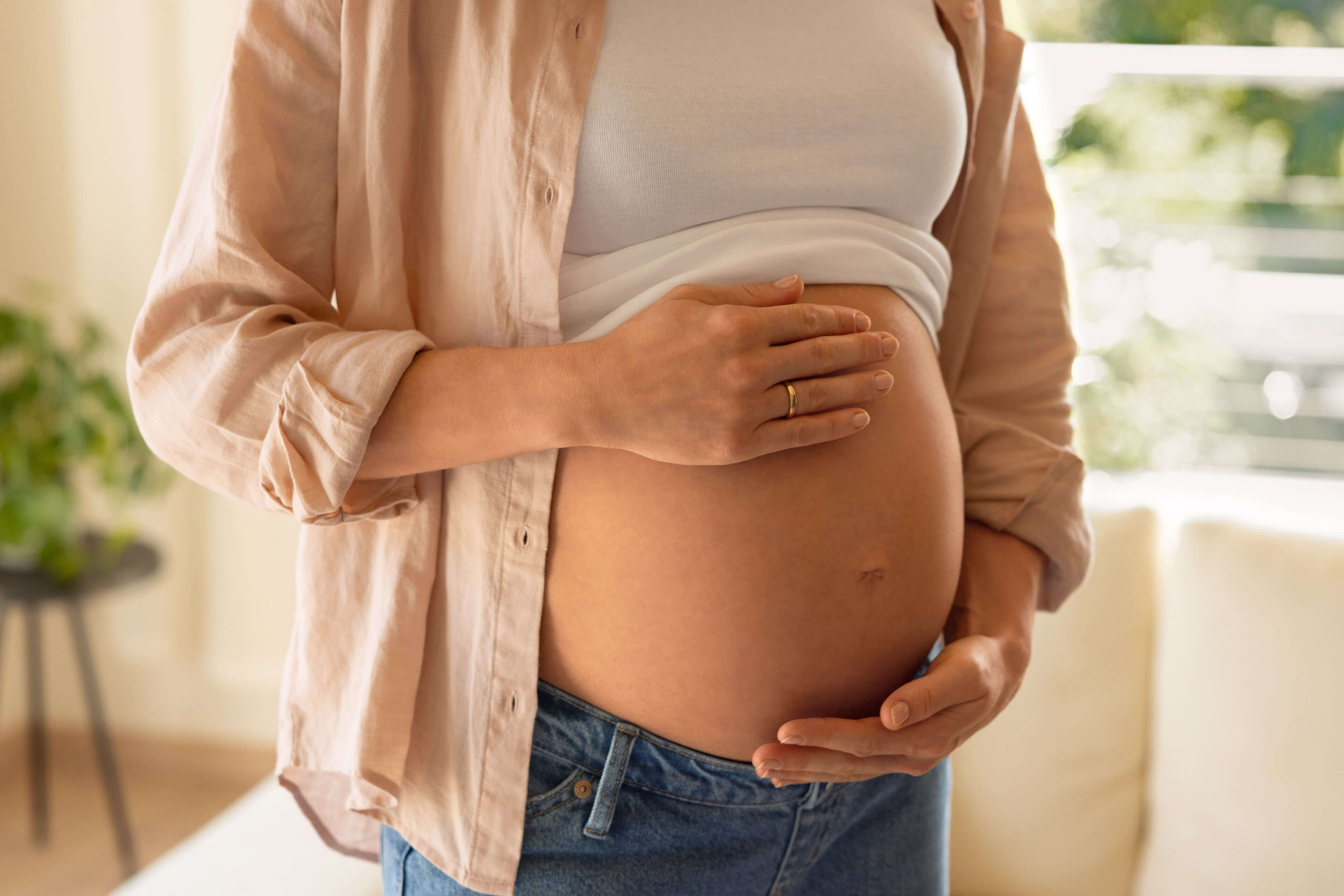 Eine Person, die schwanger ist, berührt sanft ihren Bauch.
