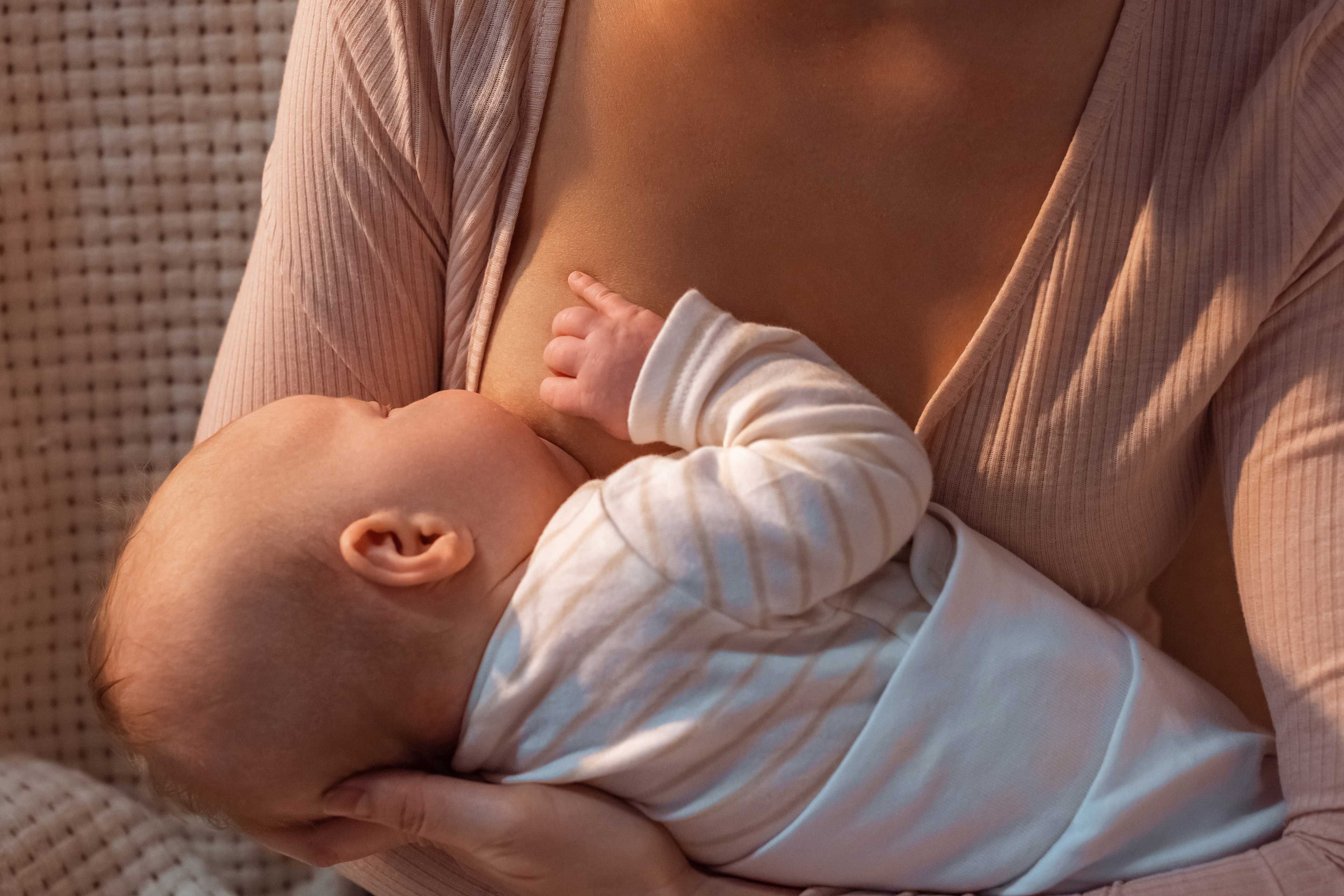 Eine Mutter hält und füttert sanft ihr Baby.