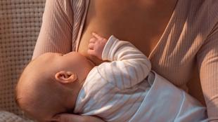 Eine Mutter hält und füttert sanft ihr Baby.