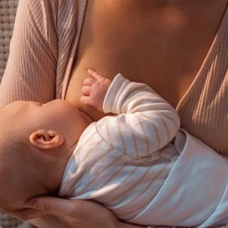 Eine Mutter hält und füttert sanft ihr Baby.