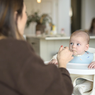 Mum spoon feeding baby
