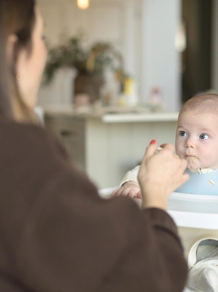 Mum spoon feeding baby