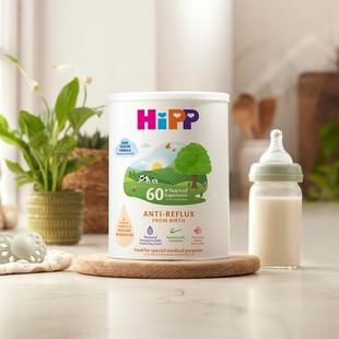 HiPP Organic anti reflux milk powder tin next to milk bottle on a kitchen worktop