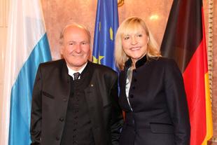 Prof. Dr. Claus Hipp und Staatsministerin Beate Merk bei der Verleihung der Bayerischen Europa-Medaille 2016 vor Europa- und Landesflaggen.
