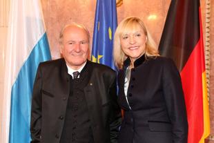 Prof. Dr. Claus Hipp und Staatsministerin Beate Merk bei der Verleihung der Bayerischen Europa-Medaille 2016 vor Europa- und Landesflaggen.