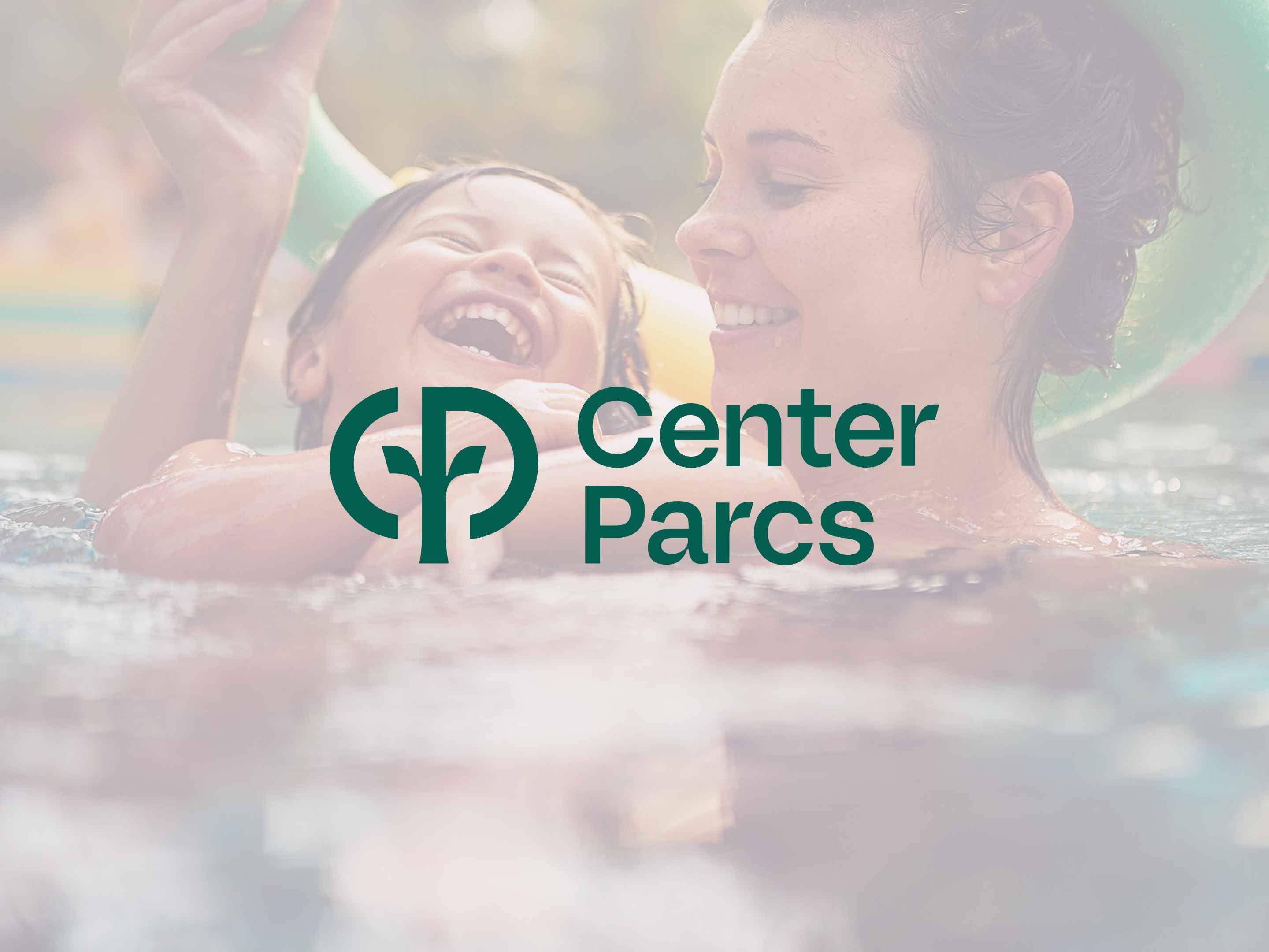 Familie mit zwei Kindern spielt im Wasser eines tropisch begrünten Schwimmbeckens