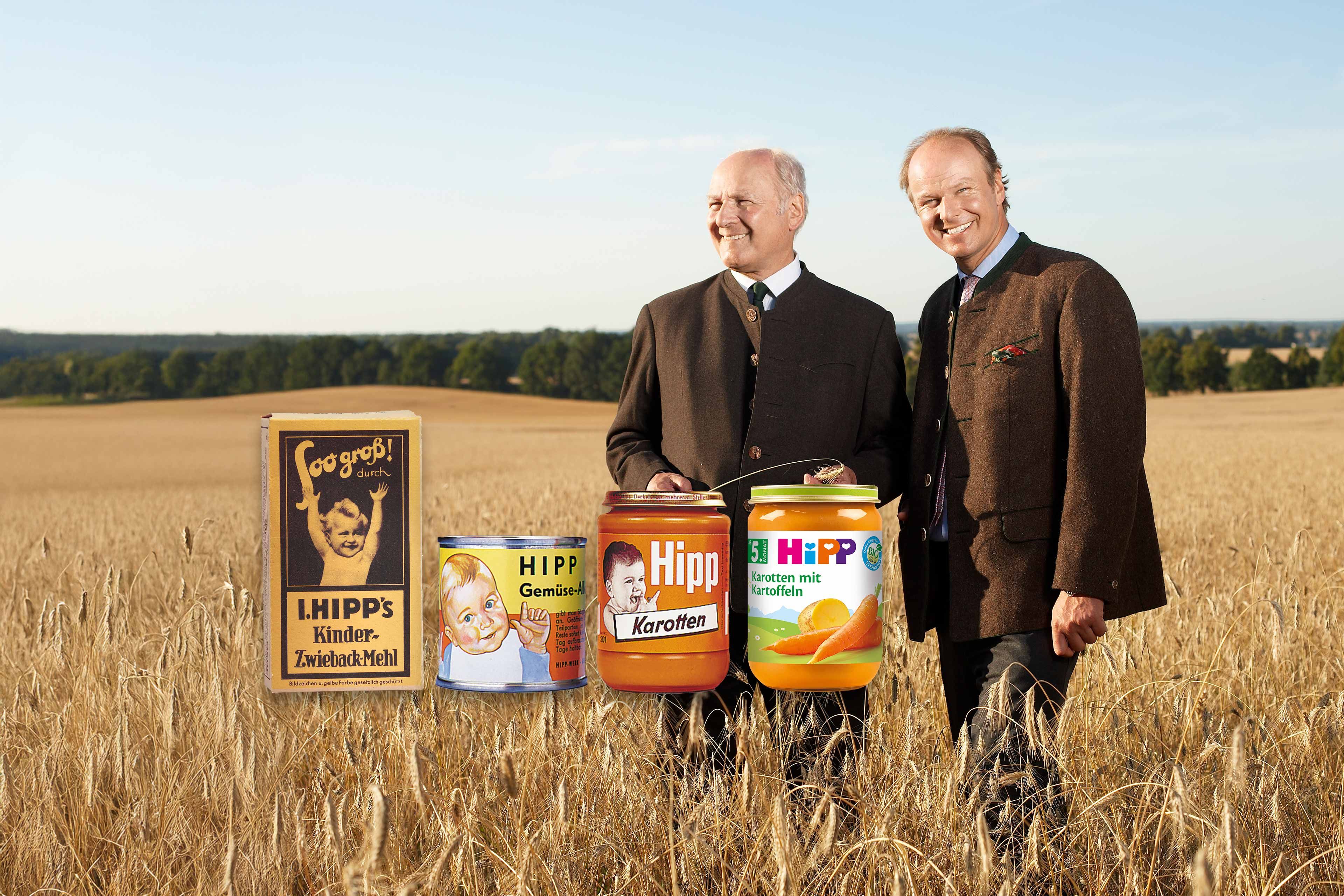 Zwei Männer im Getreidefeld neben historischen und modernen HiPP-Babygläschen, Sinnbild für die lange HiPP-Historie und Qualität.