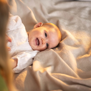 Baby lying on bed smiling