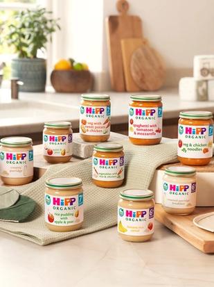 Selection of HiPP Organic 6–7 month baby food jars arranged on a bright, cosy kitchen worktop ready for early weaning.