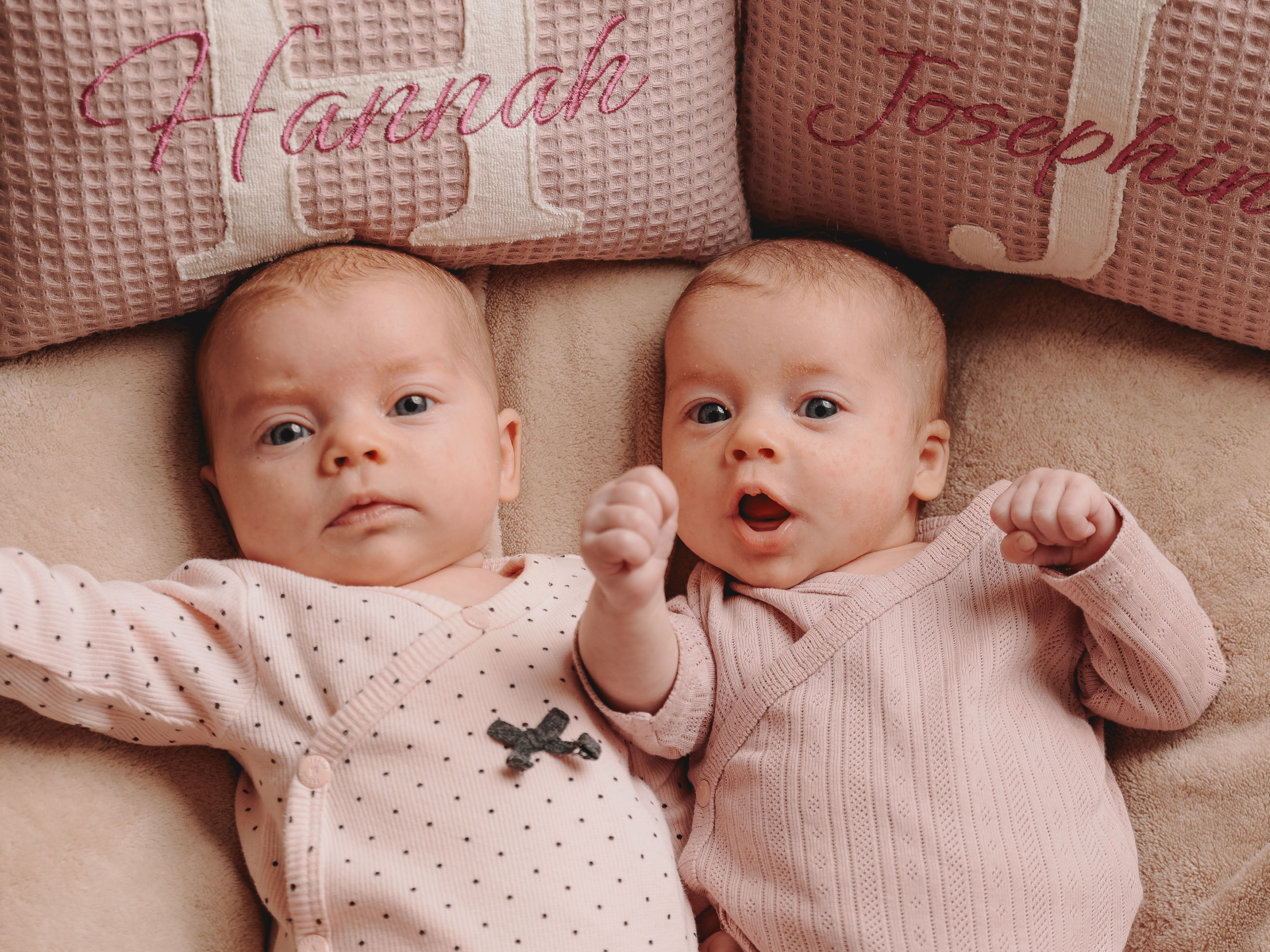 zwei Babys liegen auf einer Decke