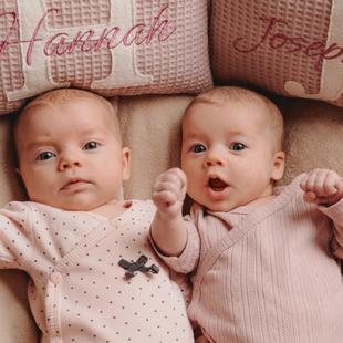 zwei Babys liegen auf einer Decke
