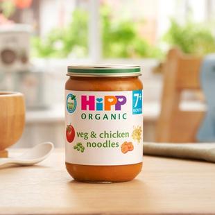 HiPP Organic Veg & Chicken Noodles jar on a dining table next to a spoon and bowl