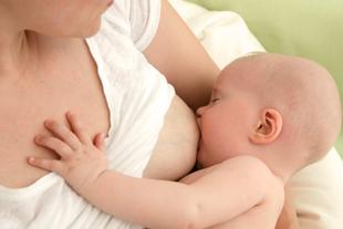 Baby trinkt an der Brust der Mutter, inniger Stillmoment als Symbol für nährstoffreiche, schützende Muttermilch