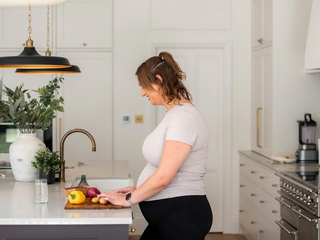 Pregnancy mum chopping vegetables in kitchen
