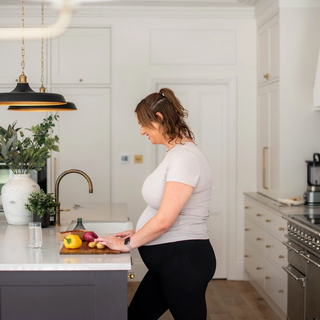 Pregnancy mum chopping vegetables in kitchen