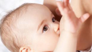 Nahaufnahme eines Babygesichts mit Schwerpunkt auf den Augen und dem Akt des Stillens.