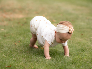 Baby crawling in grass