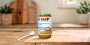 HiPP Gläschen Bulgur-Gemüsepfanne mit Kichererbsen und Wildlachs ab dem 12. Monat neben einem Löffel