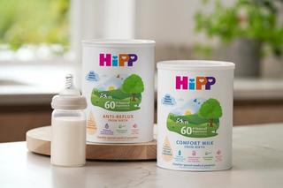 Hipp specialised milks range on a kitchen worktop next to a bottle of milk