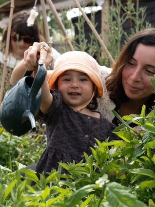 Mum and daughter using watering can in the garden