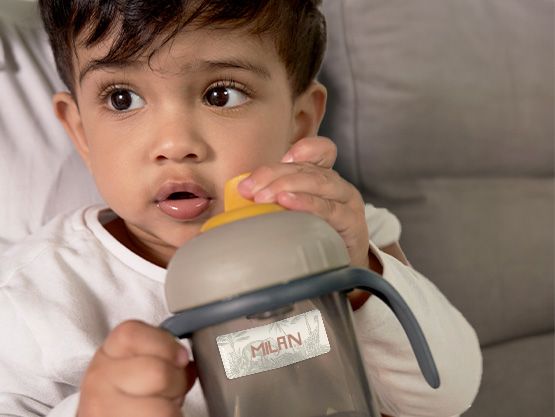 Kind mit Flasche mit Namensaufkleber