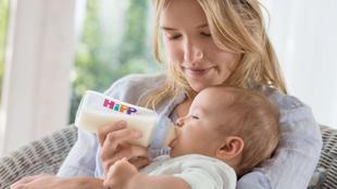 Eine Frau füttert ihr Baby mit einer Hipp-Flasche.