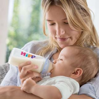 Eine Mutter, die ihr Baby mit der Flasche füttert.