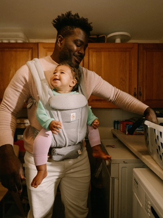 Dad babywearing whilst doing laundry