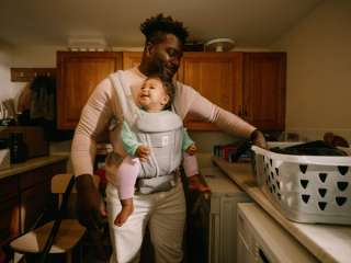 Dad babywearing whilst doing laundry