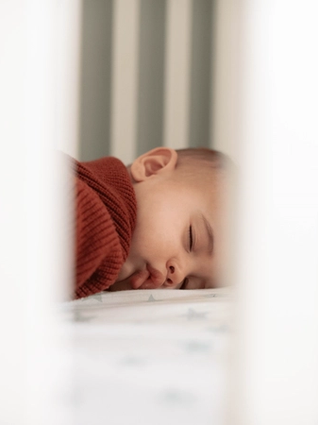 Baby sleeping in cot
