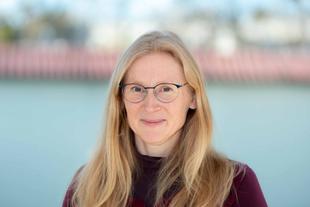 Kristin, lächelnde Ernährungswissenschaftlerin im HiPP Muttermilchforschungsteam, im Porträt vor unscharfem Hintergrund