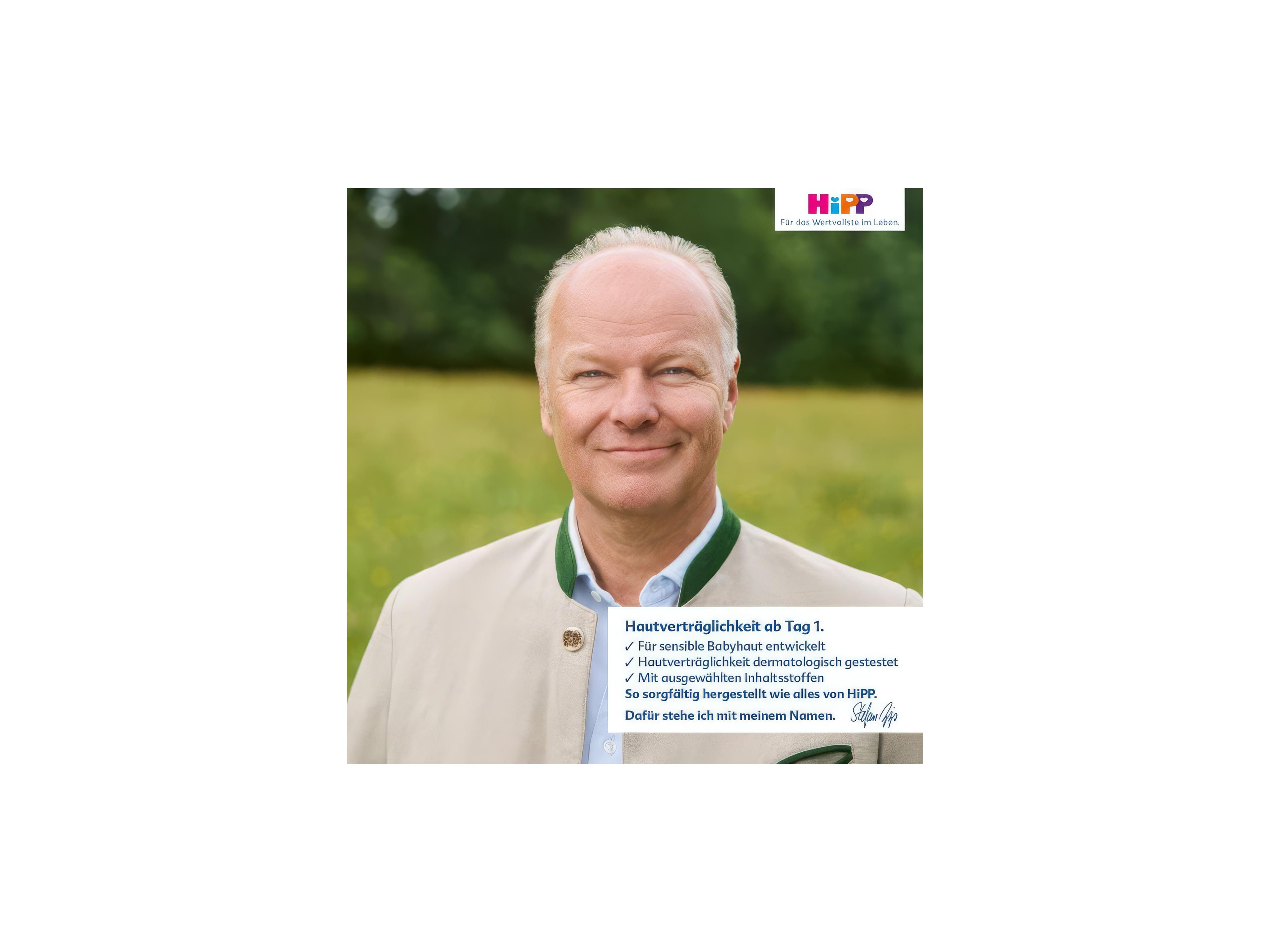 Porträt von Stefan Hipp vor unscharf grünem Hintergrund und Text mit HiPP-Logo