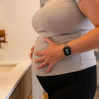 Close up of pregnant woman holding hips in pain