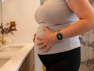 Close up of pregnant woman holding hips in pain