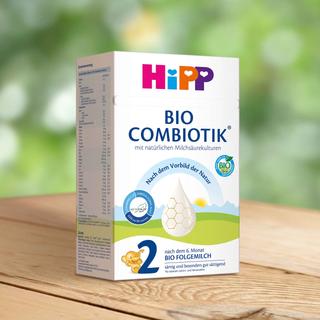 HiPP Bio Combiotik 2 Folgemilch Packung auf Holztisch, beruhigendes Naturmotiv im Hintergrund