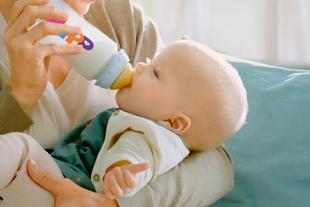 Eine Mutter füttert ihr Baby mit der Flasche.