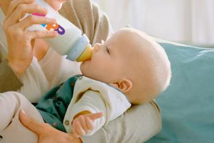 Eine Mutter füttert ihr Baby mit der Flasche.