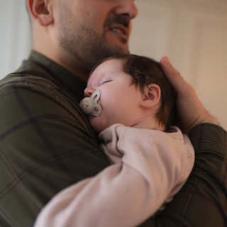 Dad holding sleeping newborn