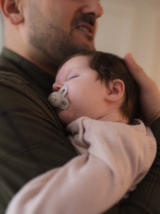 Dad holding sleeping newborn
