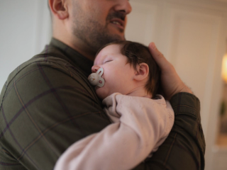 Dad holding sleeping newborn