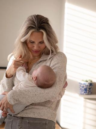 Mum holding her newborn baby in a living room
