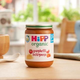 HiPP Organic Spaghetti Bolognese on a dining table next to a bowl and spoon