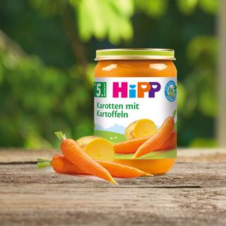 Das HiPP Gläschen Karotte mit Kartoffeln steht auf einem Holztisch