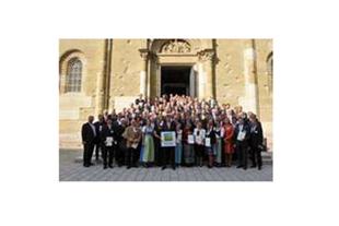 Große Gruppe von Unternehmensvertretern mit Urkunden vor der Residenzkirche München bei der Ehrung des Umweltpakts Bayern.