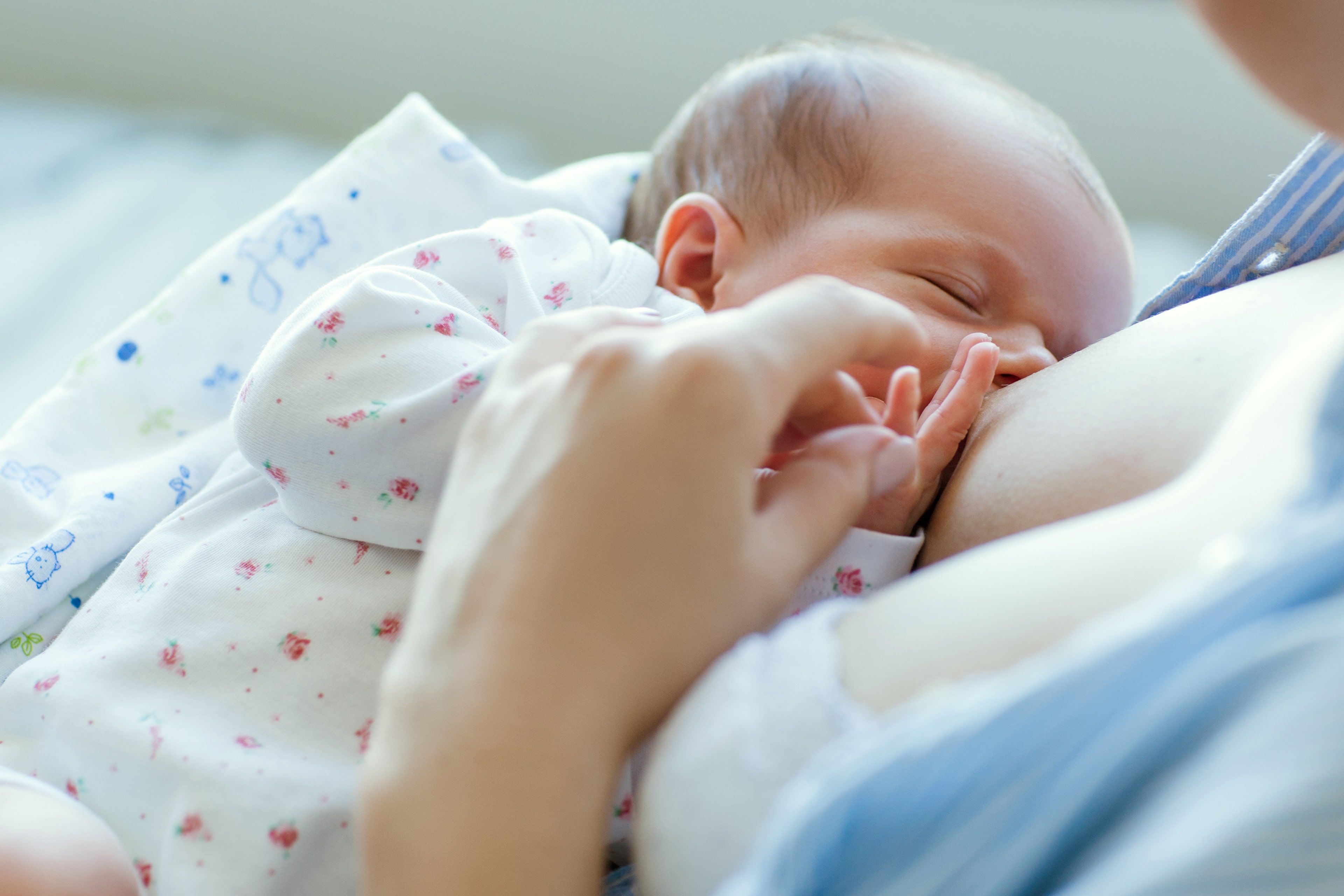 Ein zarter Moment, in dem ein Baby von seiner Mutter gestillt wird.