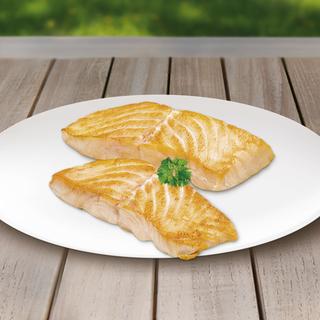 Zwei gegrillte Lachsfilets auf einem weißen Teller, garniert mit einem Zweig Petersilie.