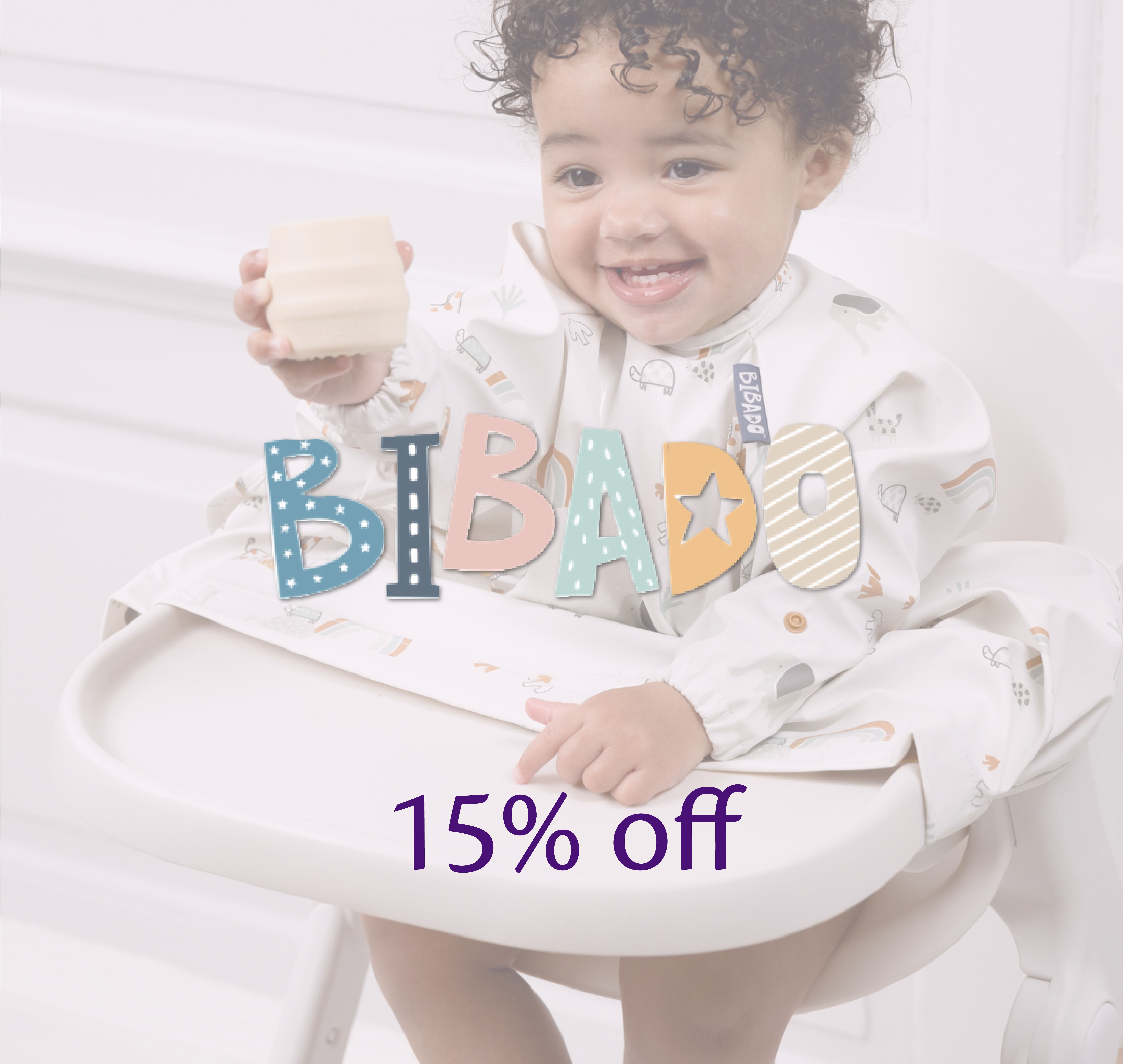 Baby smiling in a highchair wearing a Bibado coverall weaning bib and holding a cup, with the Bibado logo overlaid on the image.