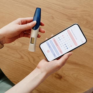 Woman holding ovulation test and cycle tracker