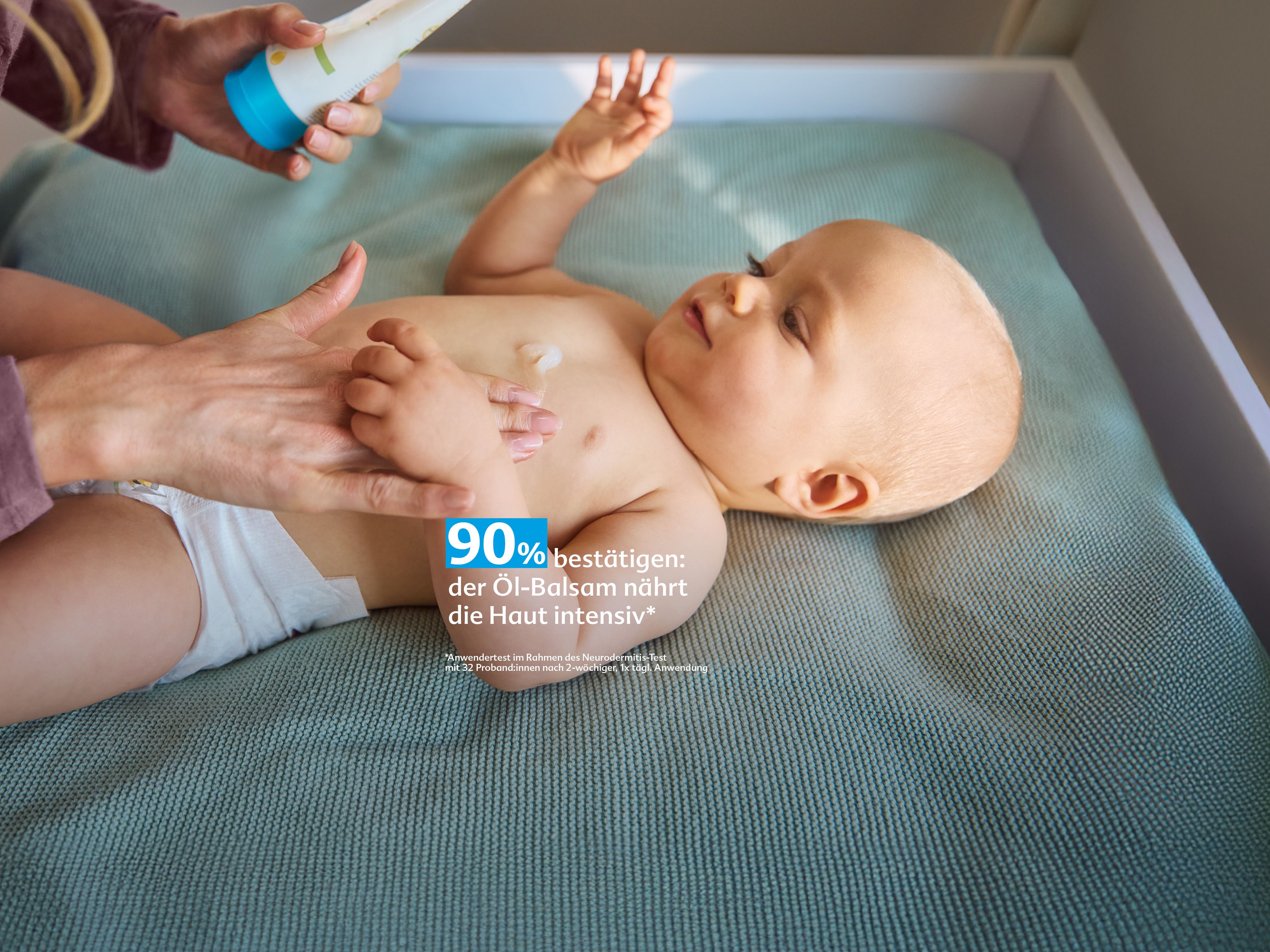 Baby auf Wickelauflage, dessen Bauch mit HiPP HOCHVERTRÄGLICH Öl-Balsam eingecremt wird, Text: „90 % bestätigen: nährt intensiv“