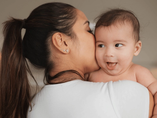 Mum kissing her baby